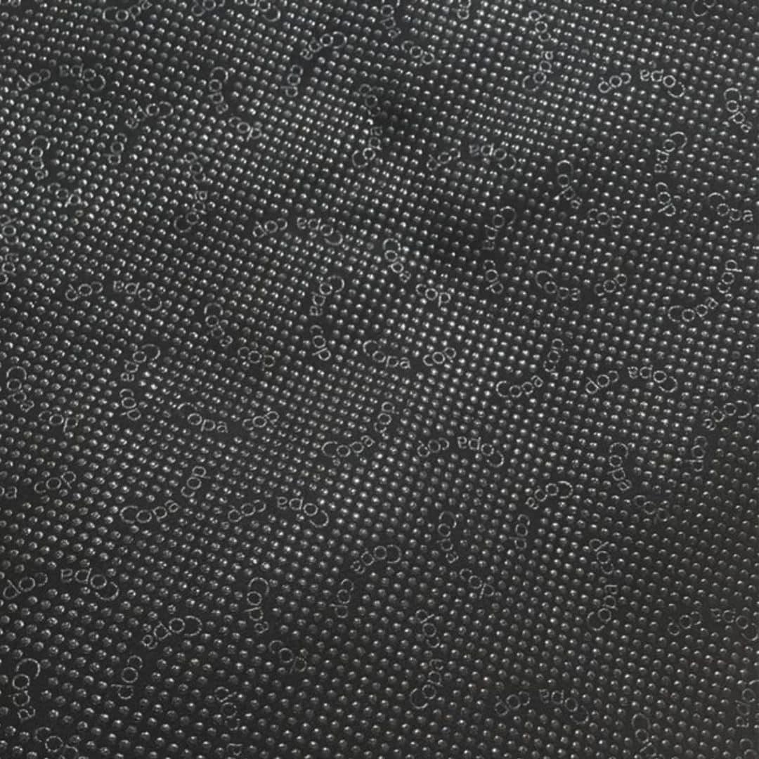 detailní pohled na texturovaný povrch s mřížkou malých vyvýšených teček. obraz má rozptýlené kruhové symboly a slovo „copa cop“ opakovaně vyražené po povrchu v různých orientacích. celkový vzor je jednotný a detailní.